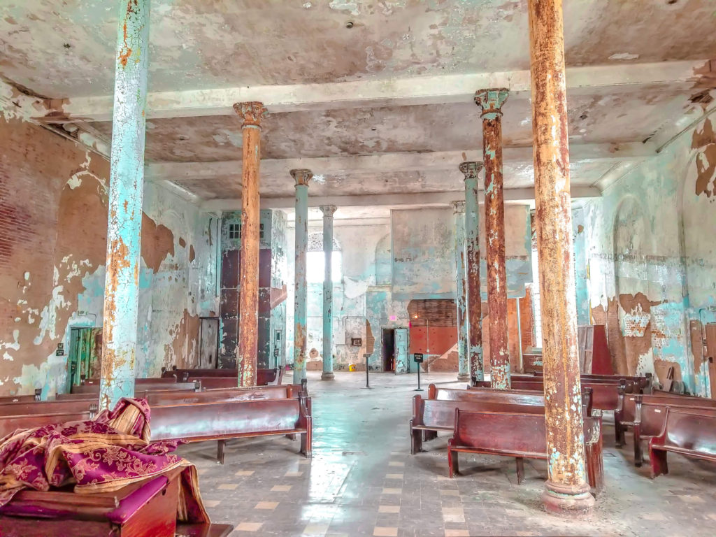 Large poles and pews inside the chapel at Mansfield Reformatory